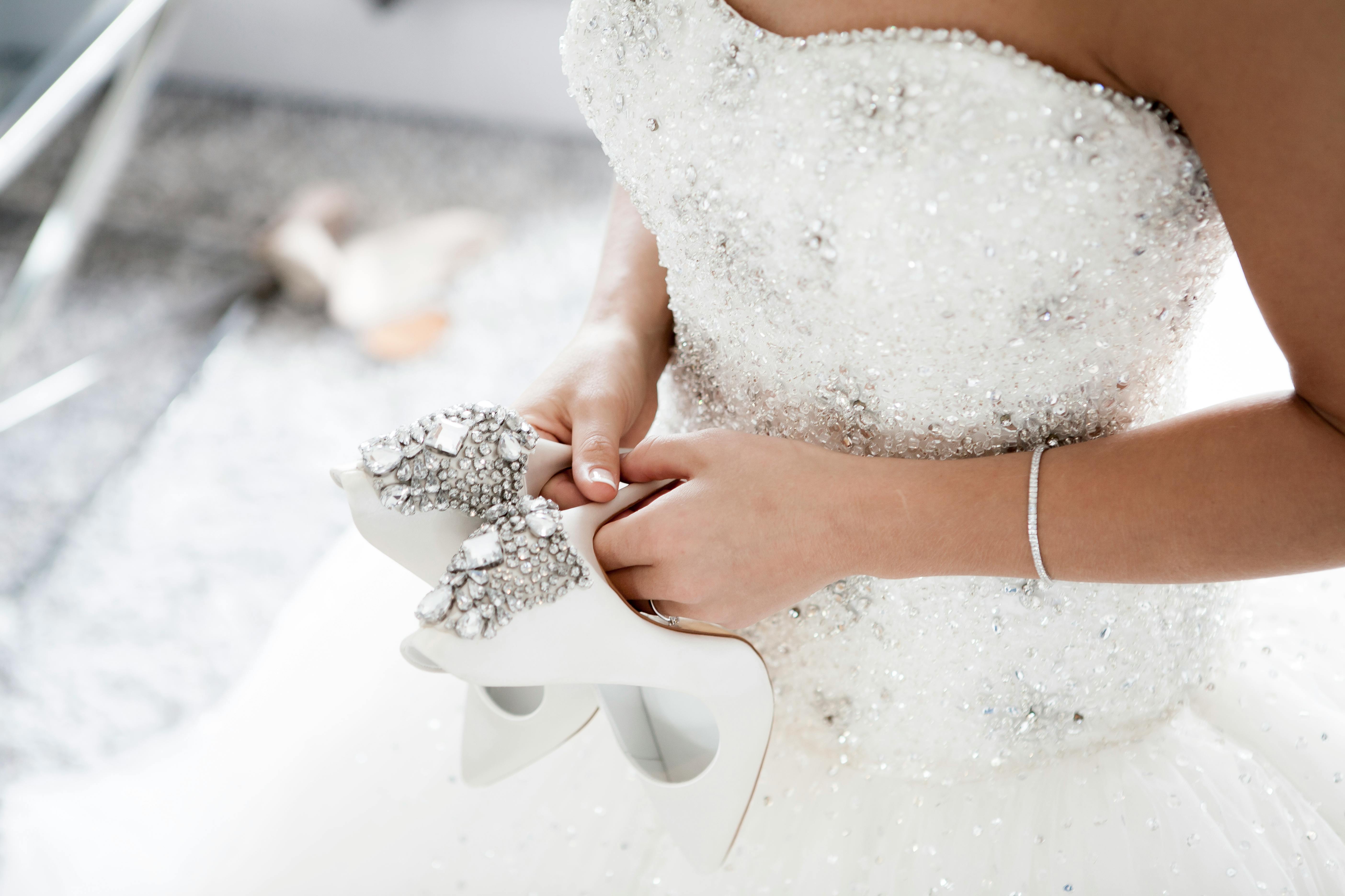 Bride holding wedding shoes